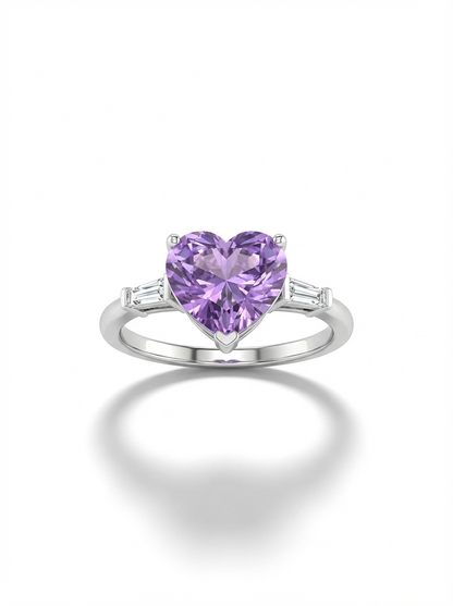 A woman's hand wearing a silver ring featuring a large, heart-shaped lavender gemstone center flanked by two small clear baguette stones.